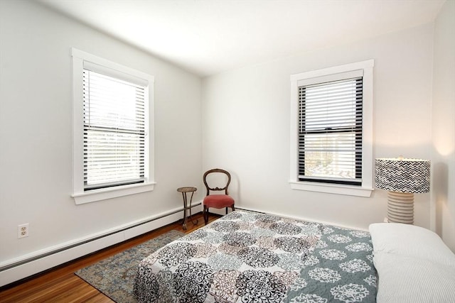 bedroom with wood-type flooring and baseboard heating