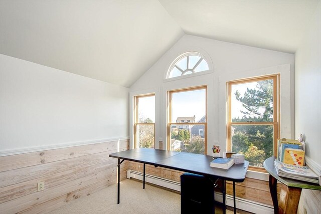 carpeted office space featuring plenty of natural light, vaulted ceiling, and a baseboard heating unit