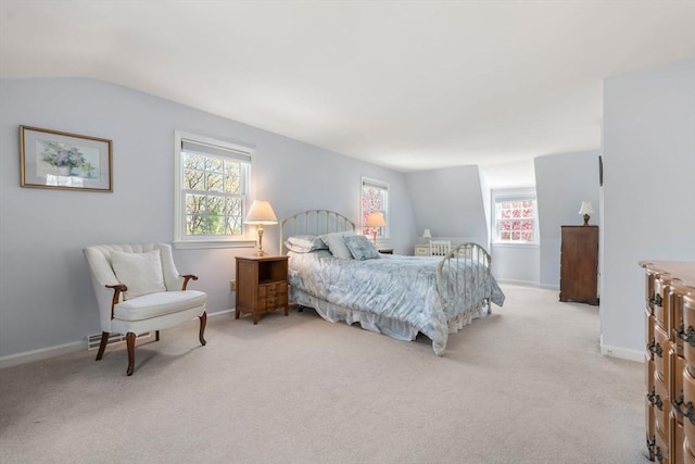 bedroom featuring multiple windows, light carpet, baseboards, and vaulted ceiling