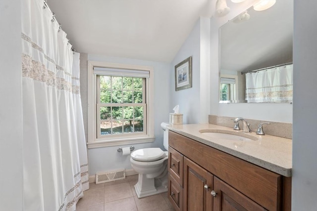 bathroom with toilet, vanity, tile patterned floors, baseboards, and vaulted ceiling
