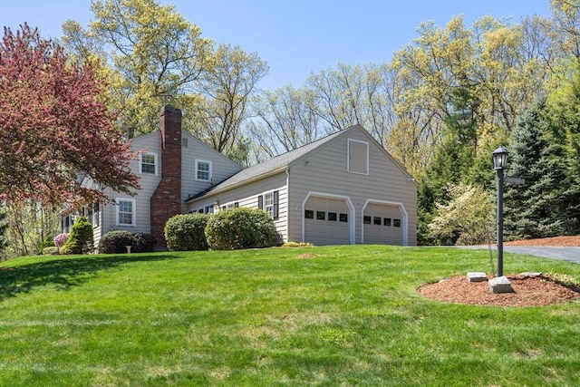 view of home's exterior featuring a garage, a yard, and a chimney
