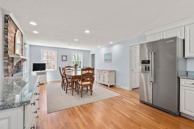 dining area with light wood finished floors, baseboards, recessed lighting, and a brick fireplace