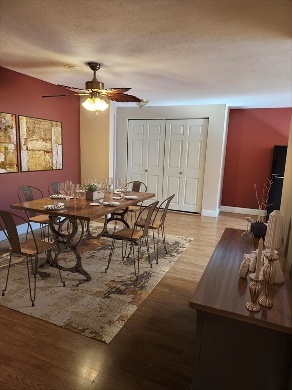 dining room featuring a textured ceiling, light hardwood / wood-style floors, and ceiling fan