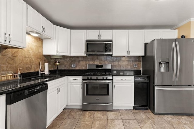 kitchen featuring sink, appliances with stainless steel finishes, white cabinets, dark stone counters, and backsplash
