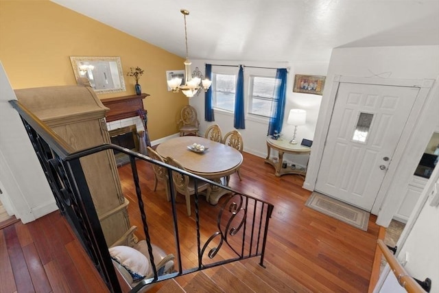 foyer with dark hardwood / wood-style flooring, a notable chandelier, and vaulted ceiling