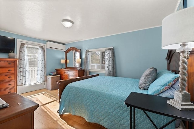 bedroom with light hardwood / wood-style flooring and a wall mounted AC