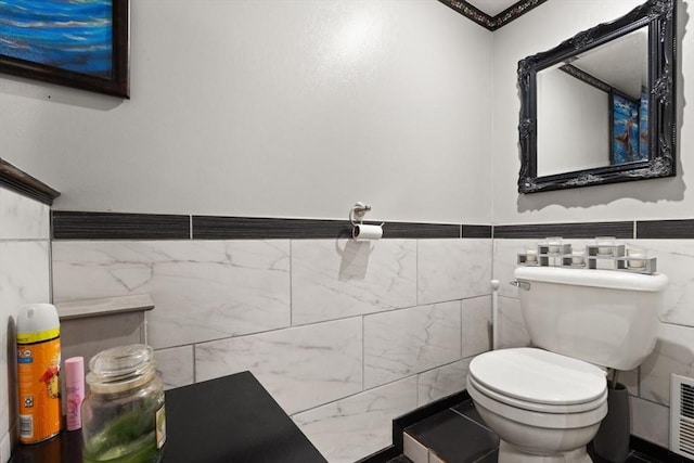 bathroom with tile walls and toilet