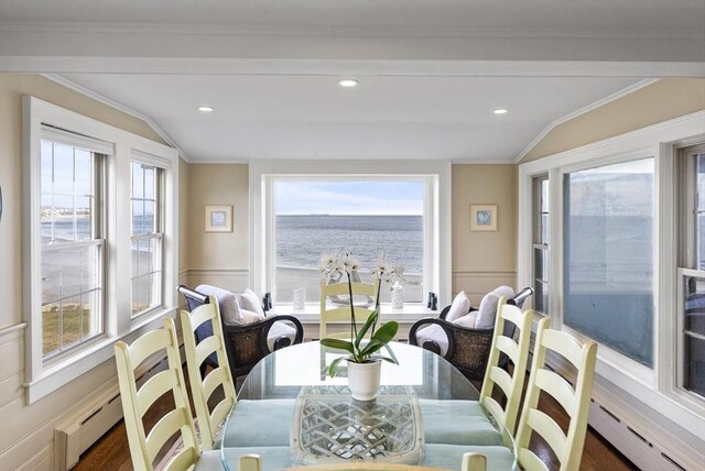 dining space featuring a water view, baseboard heating, and lofted ceiling