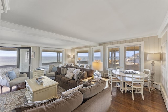 living room with beamed ceiling, ornamental molding, a water view, and dark wood-type flooring