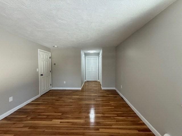 empty room featuring dark wood-type flooring and a textured ceiling