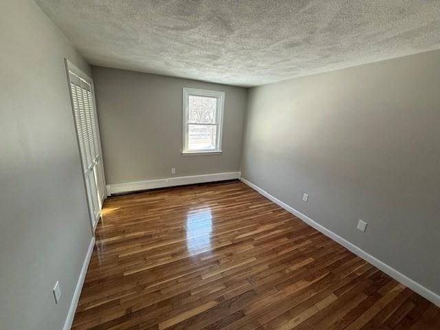 unfurnished bedroom with dark hardwood / wood-style floors and a textured ceiling