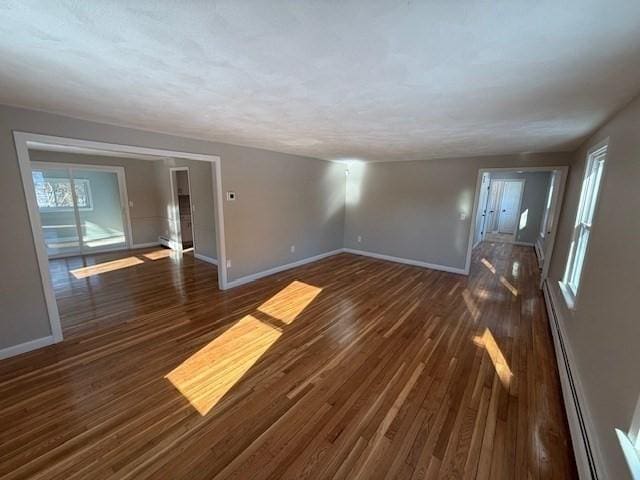 spare room featuring dark hardwood / wood-style flooring and a baseboard heating unit