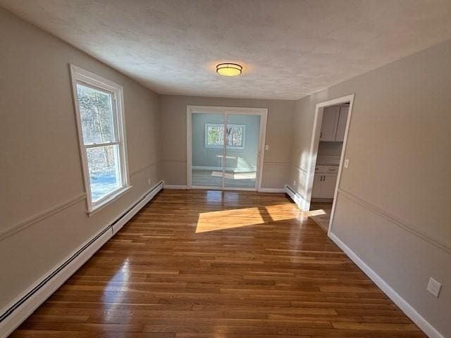 doorway with a baseboard radiator and dark hardwood / wood-style floors