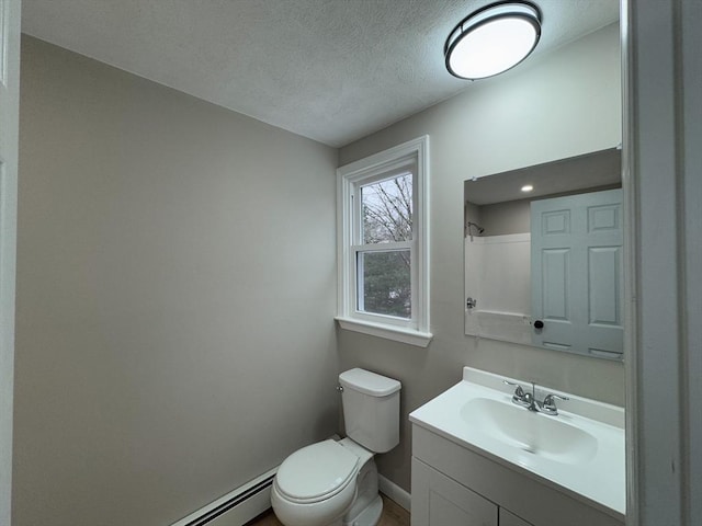 bathroom with vanity, a baseboard heating unit, a textured ceiling, and toilet