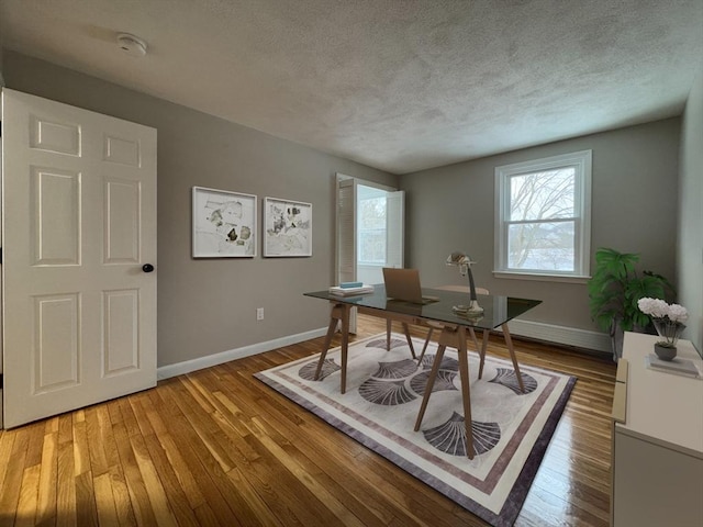 office area with hardwood / wood-style floors and a textured ceiling