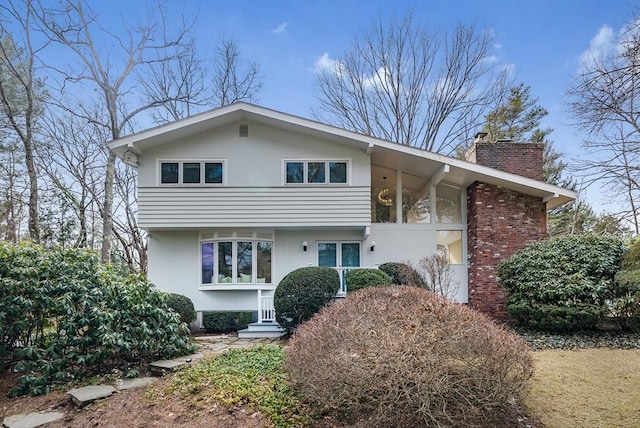 view of front of property with brick siding and a chimney