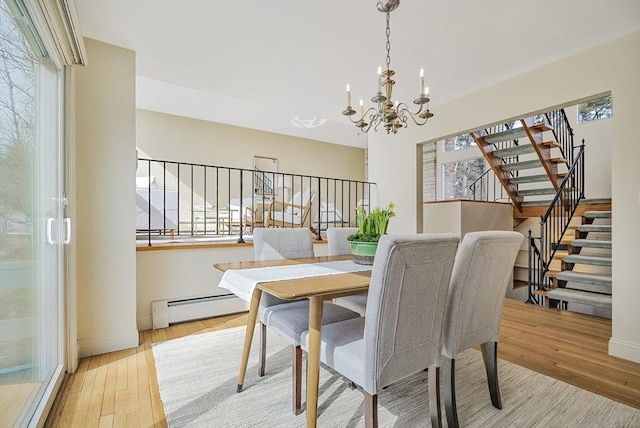 dining area with hardwood / wood-style floors, stairway, baseboards, baseboard heating, and a chandelier