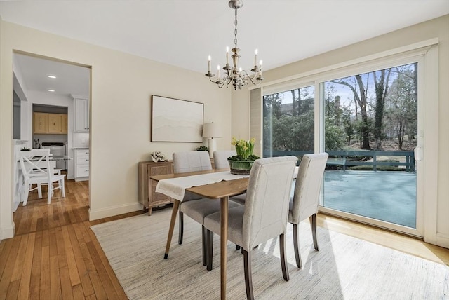 dining area with recessed lighting, a notable chandelier, baseboards, and light wood-type flooring