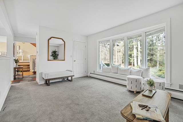 sitting room with a wealth of natural light, a baseboard heating unit, carpet floors, and stairs