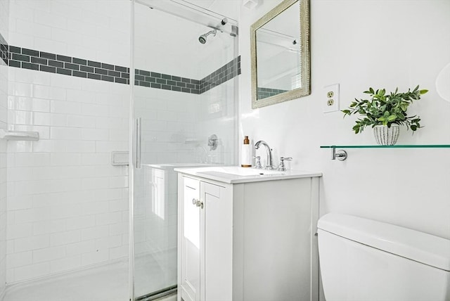 full bath featuring a stall shower, toilet, and vanity