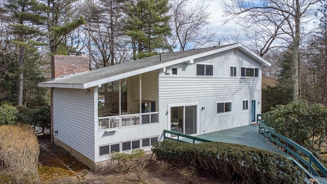 rear view of house with a chimney and a sunroom