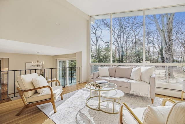 sunroom with an inviting chandelier, a healthy amount of sunlight, and a baseboard radiator