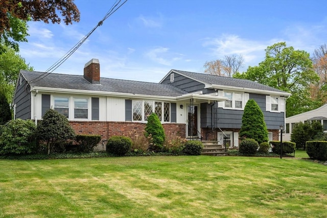50 Thompson St, Dedham, MA 02026 - split level home with a chimney, a front yard, and brick siding