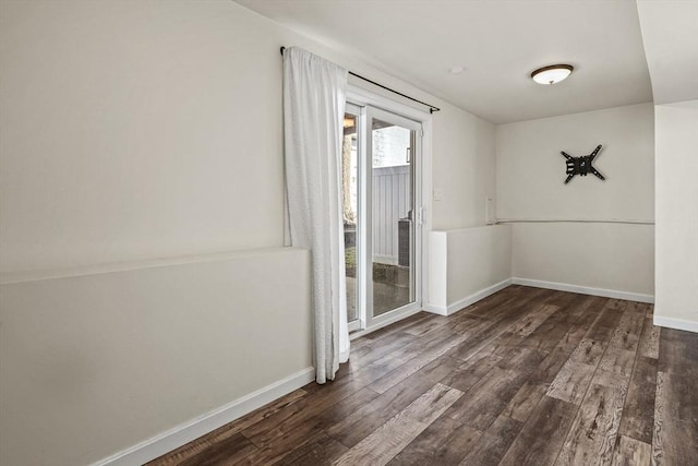 spare room featuring baseboards and wood finished floors