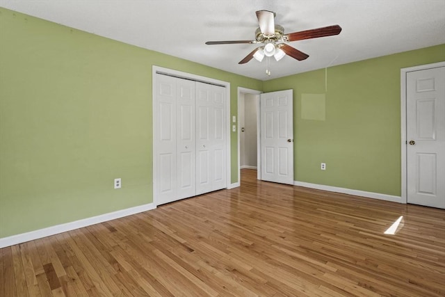 unfurnished bedroom with baseboards, a ceiling fan, a closet, and light wood finished floors