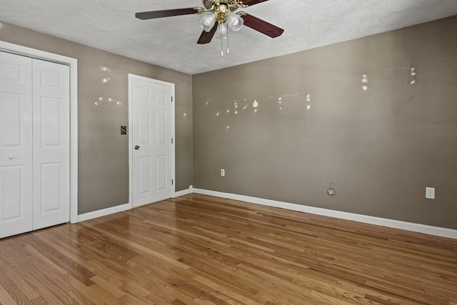 spare room featuring baseboards, a textured ceiling, ceiling fan, and wood finished floors