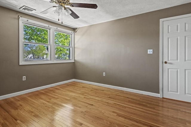unfurnished room with baseboards, a ceiling fan, light wood-type flooring, and visible vents