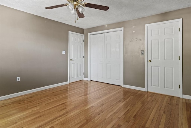 unfurnished bedroom with baseboards, a textured ceiling, light wood-style flooring, and a closet