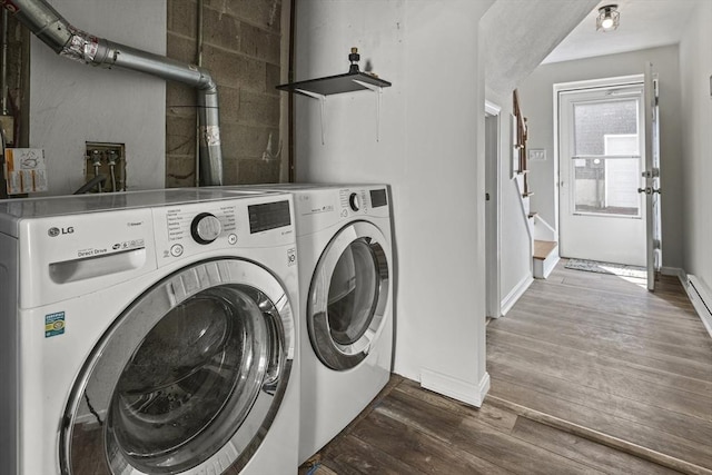 clothes washing area with baseboards, laundry area, dark wood-type flooring, and washer and clothes dryer