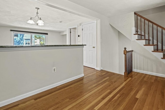 interior space featuring an inviting chandelier, baseboards, and wood finished floors
