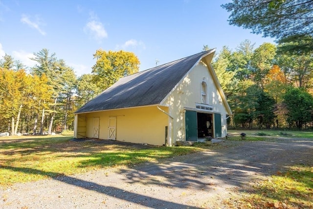 view of side of property featuring a detached garage, an outbuilding, and an outdoor structure