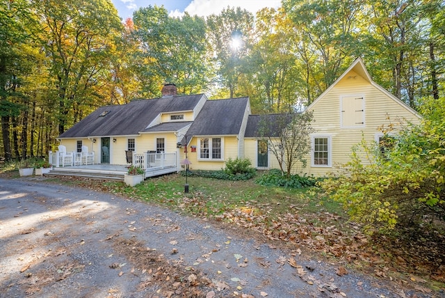 view of front of house featuring a chimney and a wooden deck