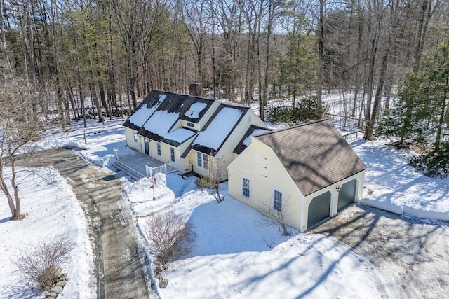 snowy aerial view featuring a wooded view