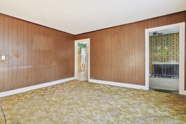 spare room featuring carpet and wood walls