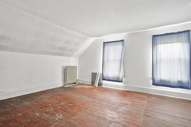 bonus room featuring radiator, hardwood / wood-style flooring, vaulted ceiling, and baseboards