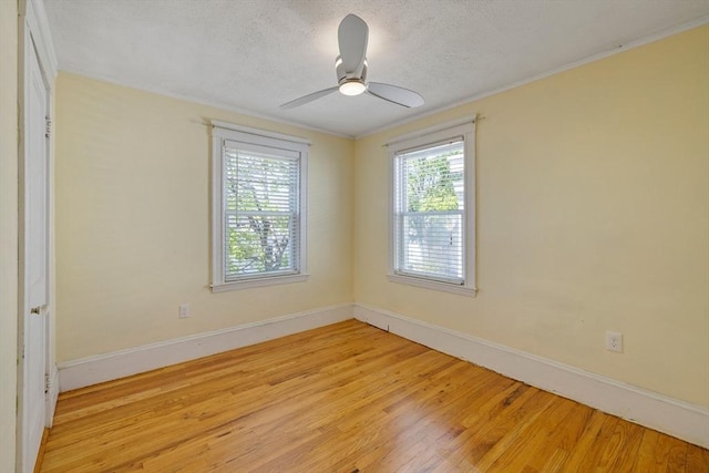 unfurnished room featuring a textured ceiling, baseboards, a ceiling fan, and light wood-style floors