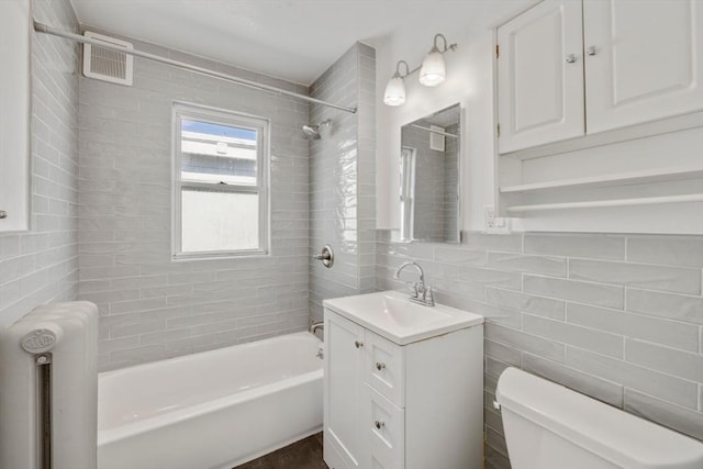 full bath with visible vents, radiator, shower / bathtub combination, toilet, and tile walls
