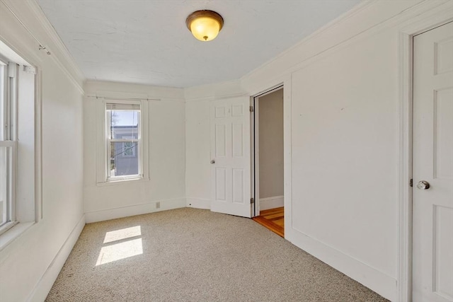 unfurnished bedroom with carpet floors, baseboards, and crown molding