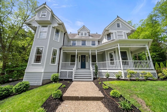 victorian home featuring a porch and a front lawn