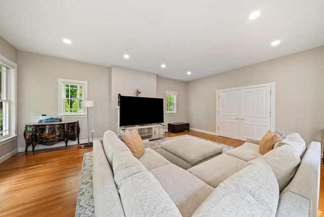 living room featuring healthy amount of natural light, light wood-style floors, recessed lighting, and baseboards