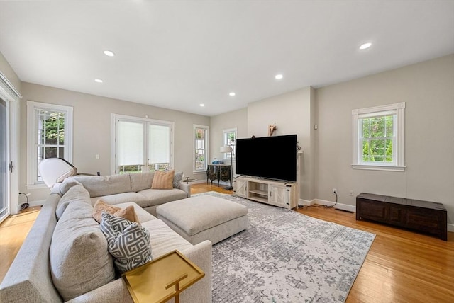 living room featuring light wood finished floors, recessed lighting, baseboards, and french doors