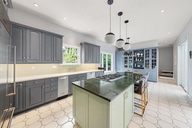 kitchen with stainless steel gas cooktop, a sink, recessed lighting, a kitchen bar, and decorative backsplash