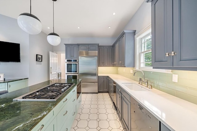 kitchen with stainless steel appliances, a sink, decorative backsplash, gray cabinetry, and recessed lighting