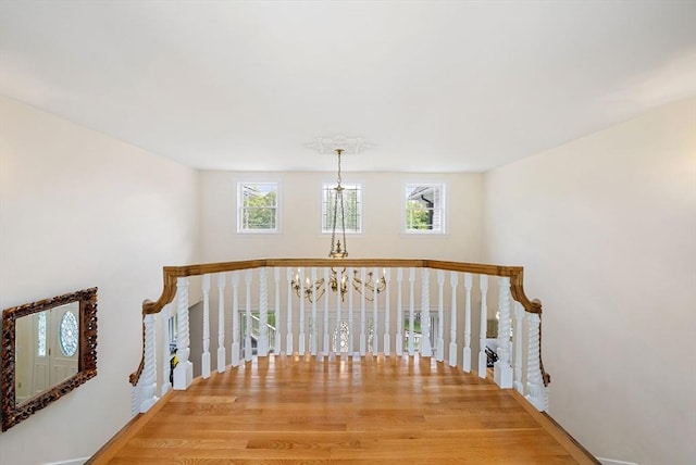hall featuring a chandelier and wood finished floors