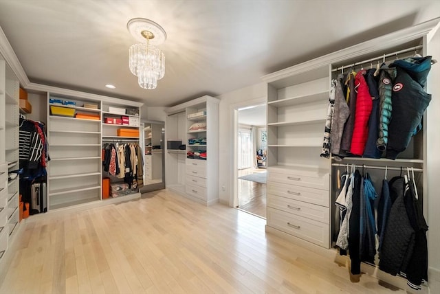 walk in closet featuring a chandelier and light wood finished floors