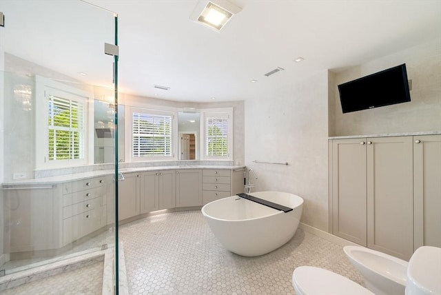 full bathroom featuring toilet, vanity, a soaking tub, and a bidet